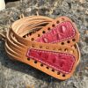 A pair of brown and red leather sandals on the rocks.