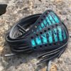 A pair of black and blue leather laces on the ground.