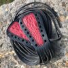 A pair of black and red leather shoe laces.