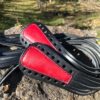 A pair of black and red leather riding crops.