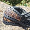 A pair of black and brown leather straps on the ground.