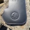 A black leather case sitting on top of a rock.