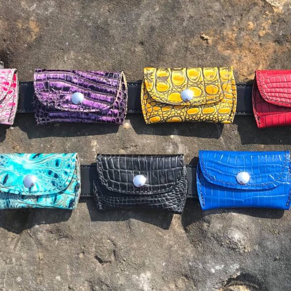 A group of different colored wallets sitting on top of rocks.