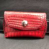 A red wallet is sitting on the leather surface.