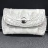 A white leather wallet sitting on top of a table.