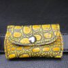 A yellow and black wallet sitting on top of a table.