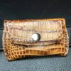 A brown leather wallet sitting on top of the ground.