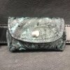 A wallet with a heart on it is sitting in the middle of a leather purse.