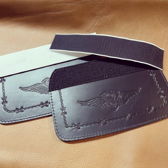 A pair of black leather wallets with an eagle on the front.