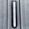 A metal object with a black and white strip on it.