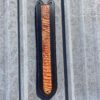 A black and brown wooden object hanging on the side of a building.