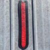 A red and black strip hanging on the side of a building.