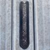 A metal door handle with a black and silver design.