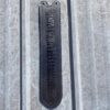A black ruler hanging on the side of a building.