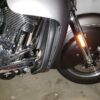 A motorcycle parked in the garage with its front tire on.