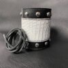 A leather bracelet with rivets and white crock.