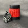 A red and black leather cuff with some gray cords