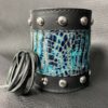 A leather cuff with blue and black design.
