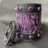 A purple and black leather cuff with silver studs.