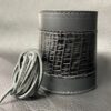 A leather wrapped container with cords on top of it.