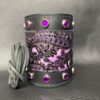 A purple and black leather cuff with silver studs.