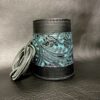 A black and blue leather cup holder with a paisley design.