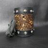 A leather cuff with a black and brown design.