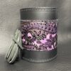 A purple and black leather cuff with a pink paisley design.