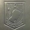 A close up of the logo on a metal plaque.