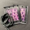 A pair of purple and black leather wallets with cords.