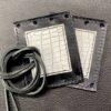 A pair of leather wallets with cords on top.