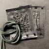 A pair of metal squares with leather straps.