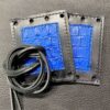 A pair of blue and black wallets with leather straps.
