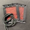 A pair of leather wallets with a string attached to them.