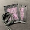 A pair of pink and black wallets with a leather cord.