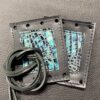 A pair of leather wallets with a belt on top.