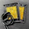 A pair of black and yellow leather wallets with cords.