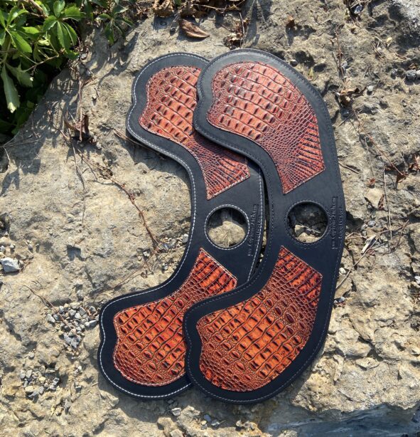 A close up of the bottom part of an orange and black shoe.