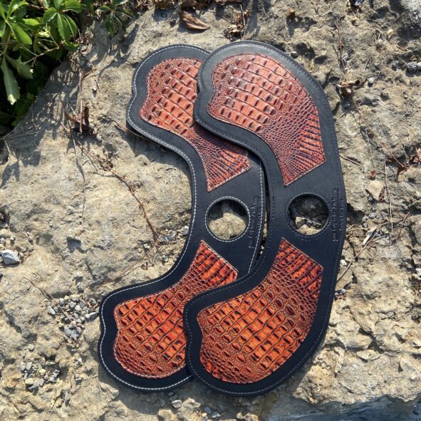 A close up of the bottom part of an orange and black shoe.