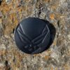 A black air force logo on the side of a rock.