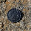 A coin sitting on top of a rock.