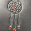 A silver dreamcatcher with red stones on it.