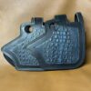 A black leather purse with a pattern of croccoths.
