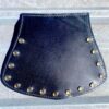 A black leather purse with gold rivets on the outside.