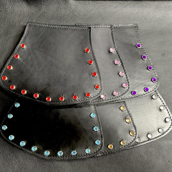 A pair of black leather bags with colored rivets.