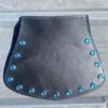 A black leather purse with blue rivets on the outside.