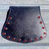 A black leather purse with red rivets on the front.