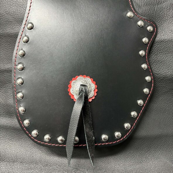 A black leather purse with red and silver rivets.